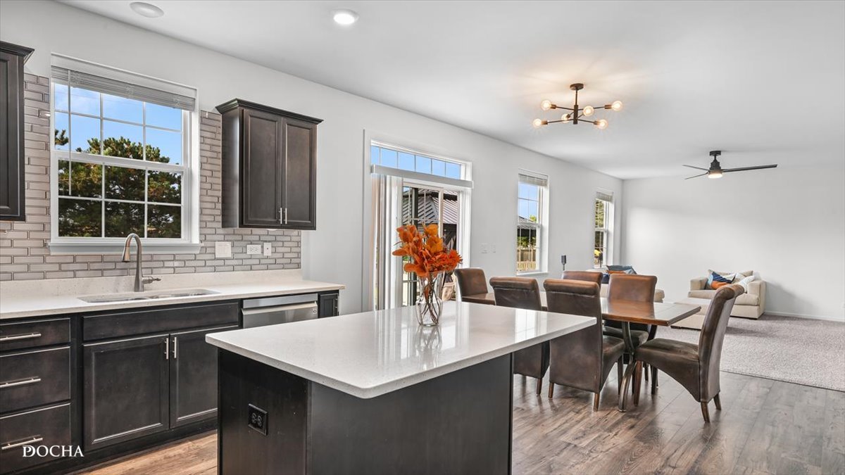26827 Ashgate Crossing Plainfield, IL 60585 - Photo 4 of 31 a kitchen with a dining table chairs sink and granite counter tops