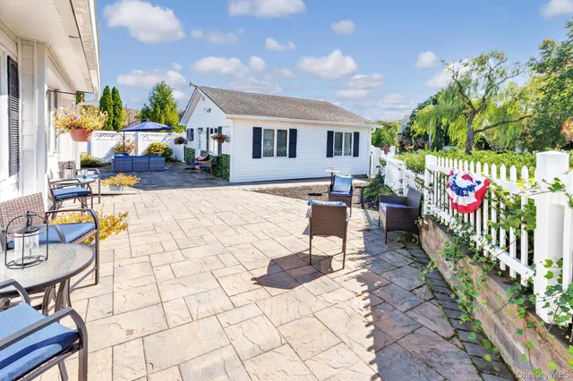 a view of a patio with a table and chairs under an umbrella
