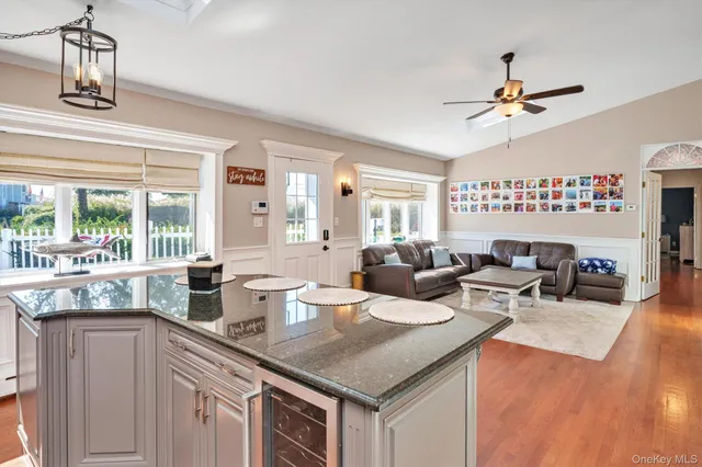 a kitchen with a sink dishwasher a stove and white cabinets with wooden floor