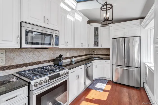 a kitchen with stainless steel appliances granite countertop a stove a refrigerator and a microwave