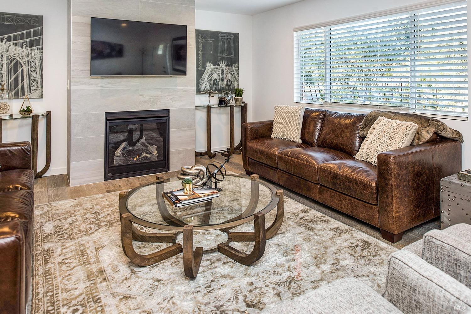 3002 Foothill Boulevard Calistoga, CA 94515 - Photo 17 of 60 a living room with furniture a flat screen tv and a fireplace
