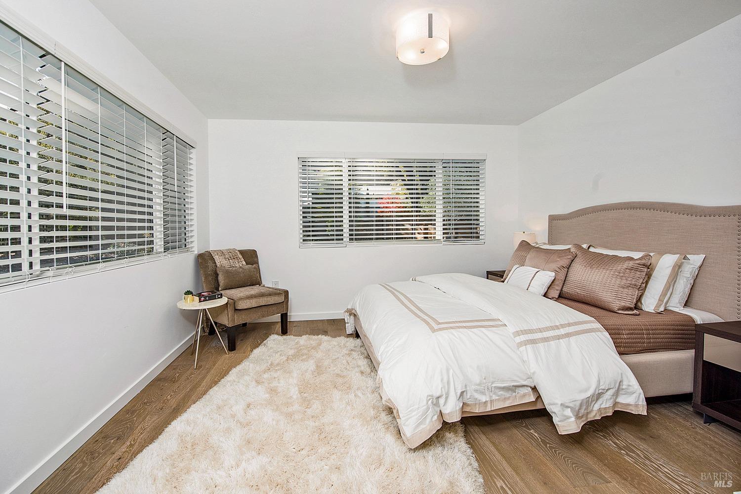 3002 Foothill Boulevard Calistoga, CA 94515 - Photo 33 of 60 a bedroom with a bed table and wooden floor