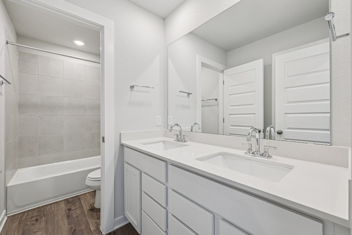 1212 Lavender Way Georgetown, TX 78628 - Photo 19 of 32 a bathroom with a granite countertop sink a toilet and a bathtub