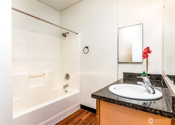 a bathroom with a granite countertop sink and a mirror