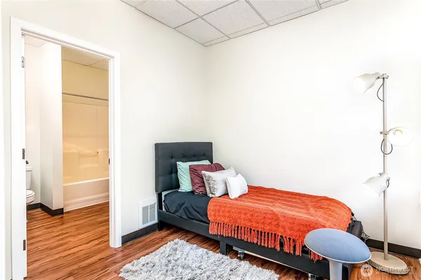 a bedroom with a bed and wooden floor