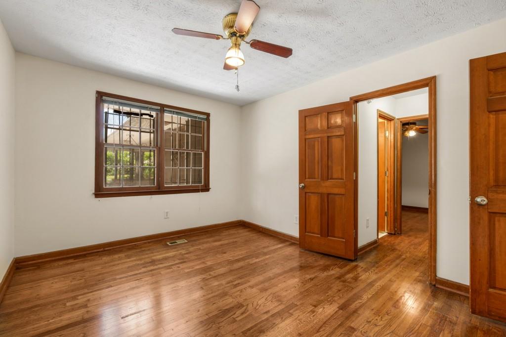 1930 Hollywood Road Northwest Atlanta, GA 30318 - Photo 13 of 19 an empty room with wooden floor chandelier fan and windows