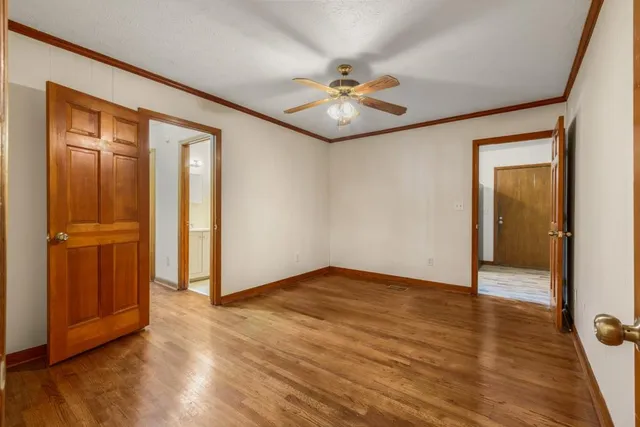 an empty room with wooden floor hallway and closet area