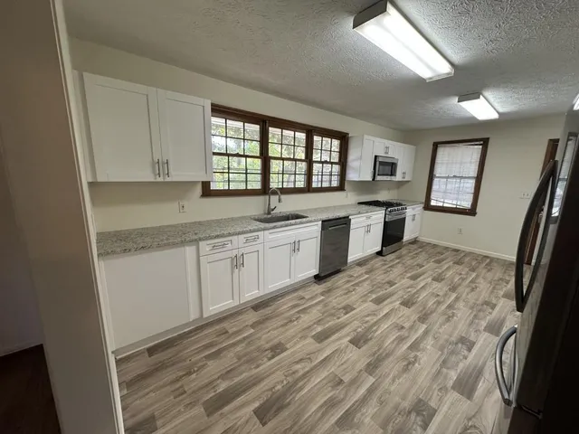 a kitchen with a sink stove and cabinets