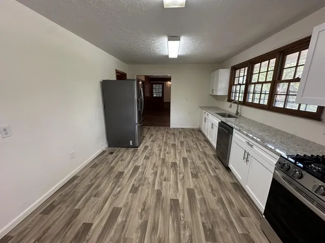 a kitchen with a sink and wooden floor