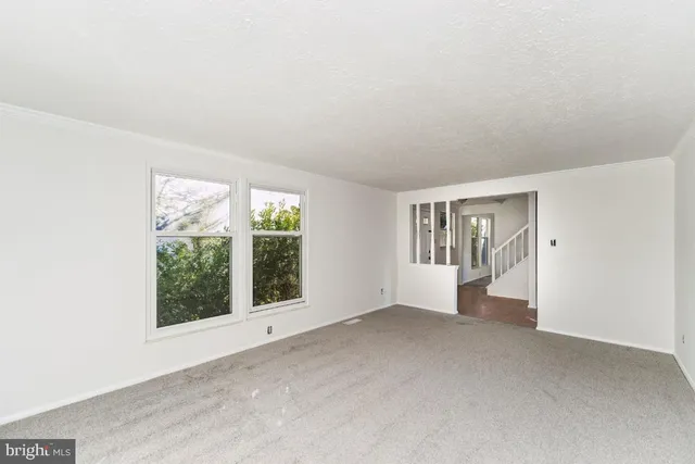 an empty room with windows and fireplace