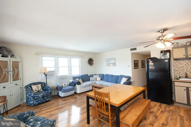 a living room with furniture stove and a refrigerator