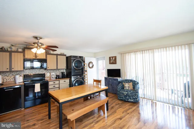 a living room with furniture a flat screen tv and kitchen view