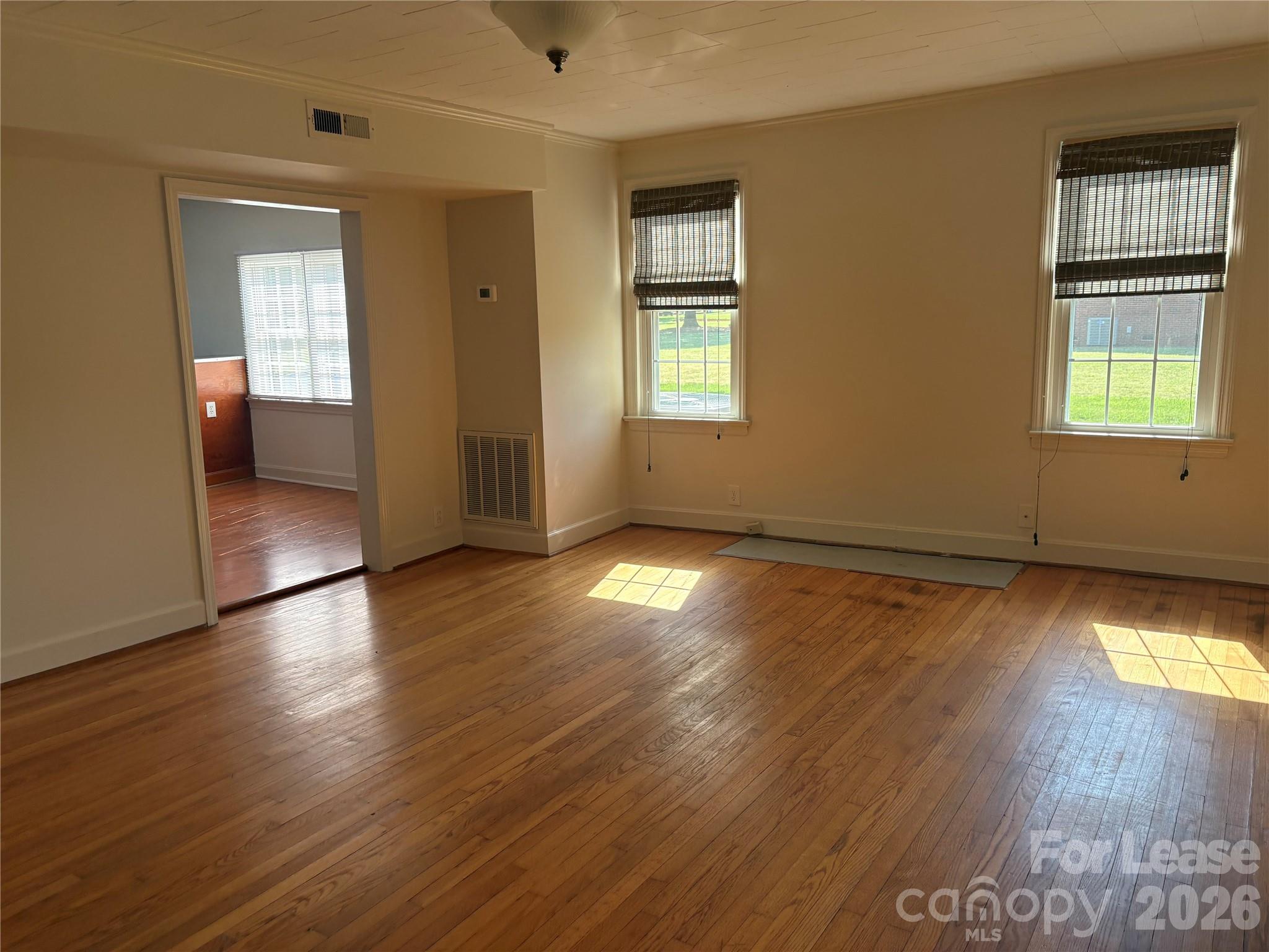 6625 Long Road Matthews, NC 28104 - Photo 11 of 21 an empty room with wooden floor and windows
