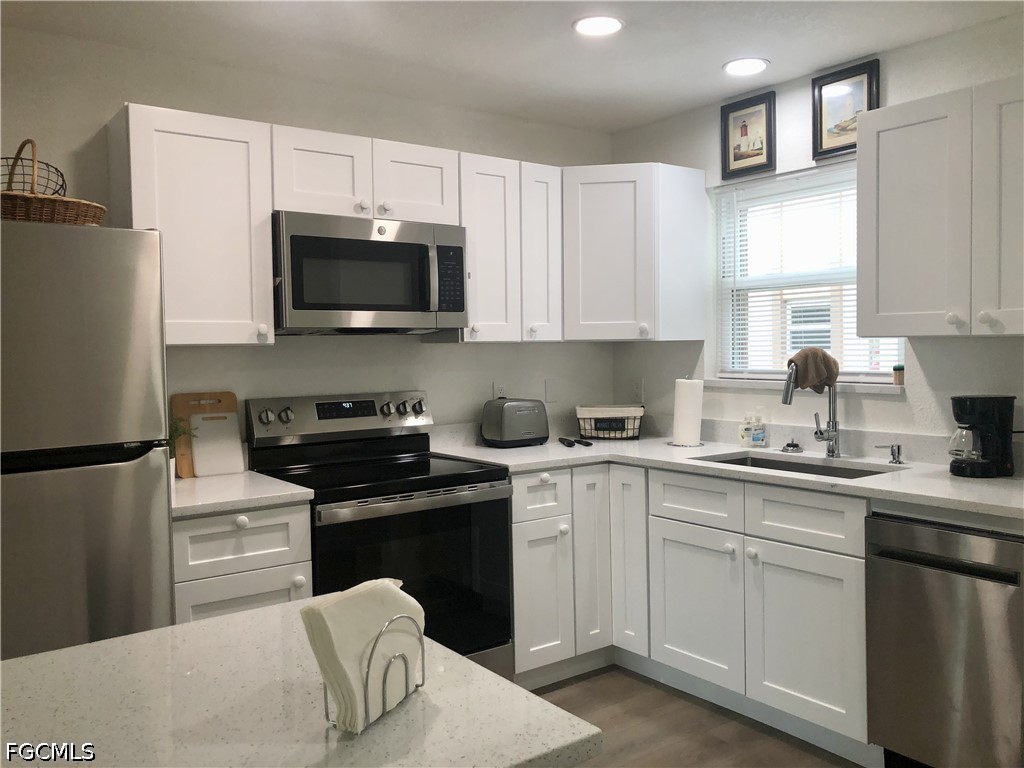 16881 Davis Road, Unit 214 Fort Myers, FL 33908 - Photo 9 of 46 a kitchen with cabinets stainless steel appliances and a sink