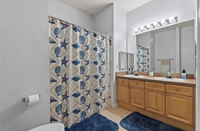 a bathroom with a double vanity sink mirror and shower