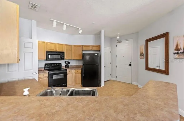 a kitchen with stainless steel appliances a refrigerator and a stove top oven