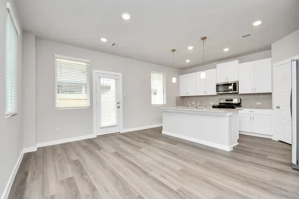 a view of kitchen with granite countertop stainless steel appliances refrigerator oven stove microwave and cabinets
