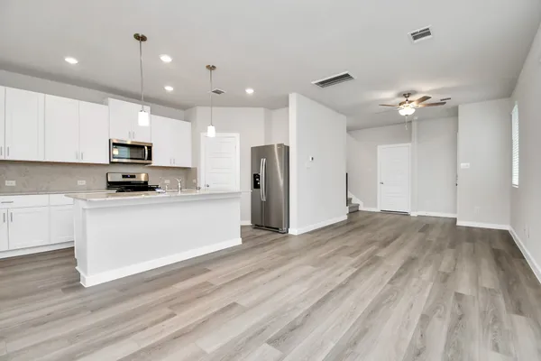 a view of kitchen with granite countertop cabinets and refrigerator
