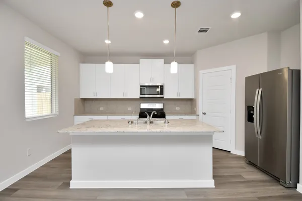 a view with kitchen island a sink wooden floor and a refrigerator