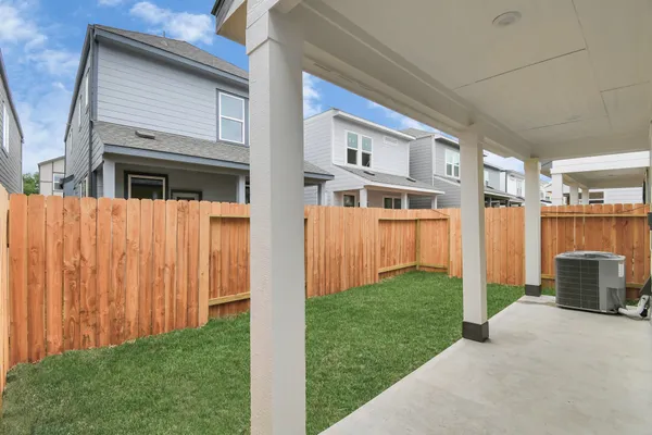 a view of a house with backyard and wooden fence
