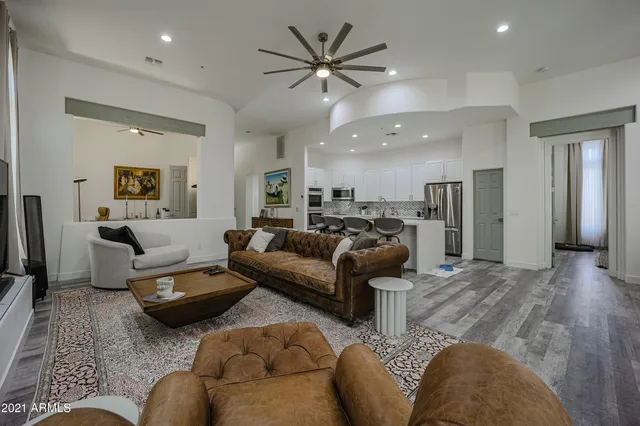 a living room with furniture and a view of kitchen