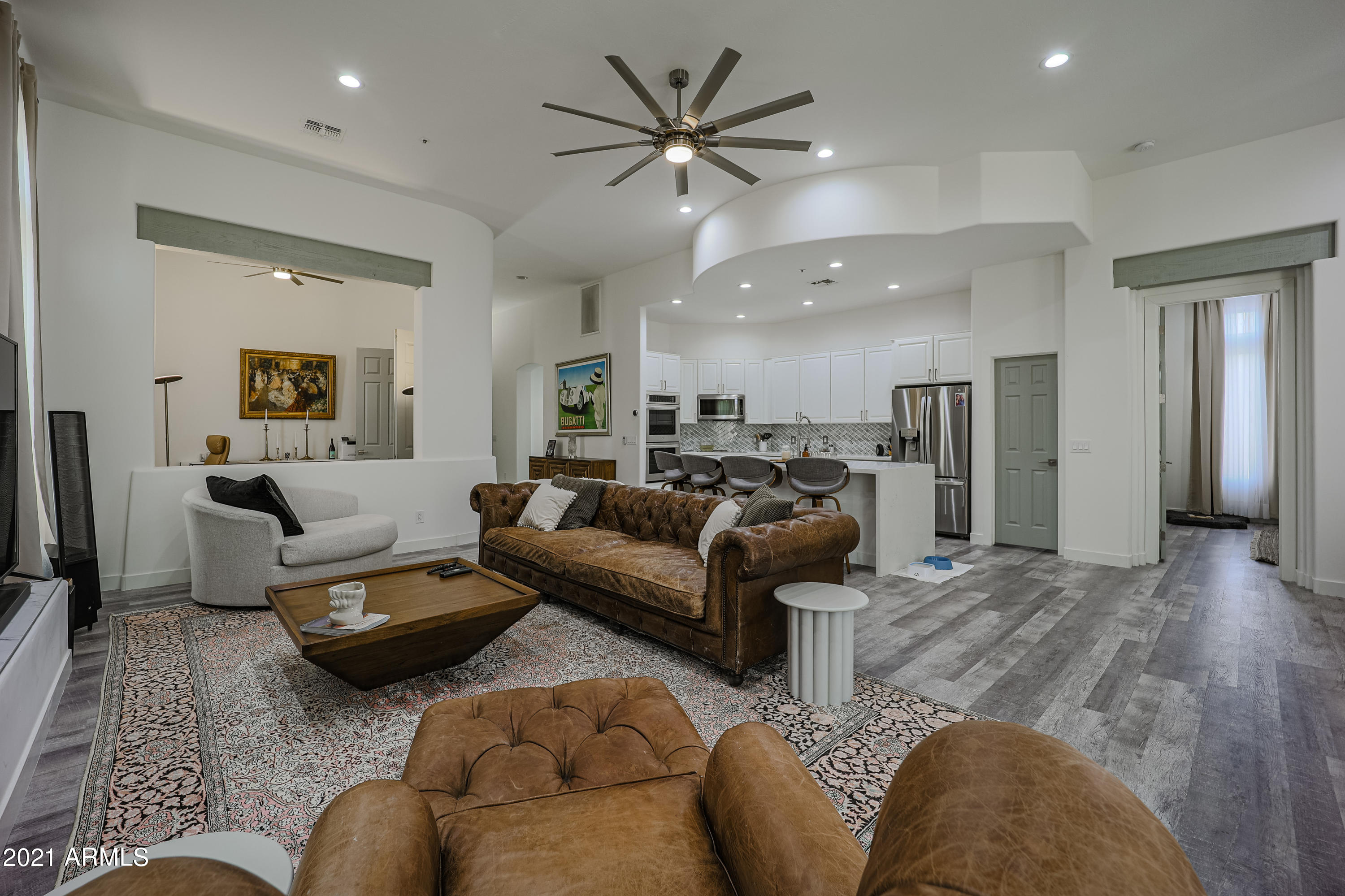 a living room with furniture and a view of kitchen