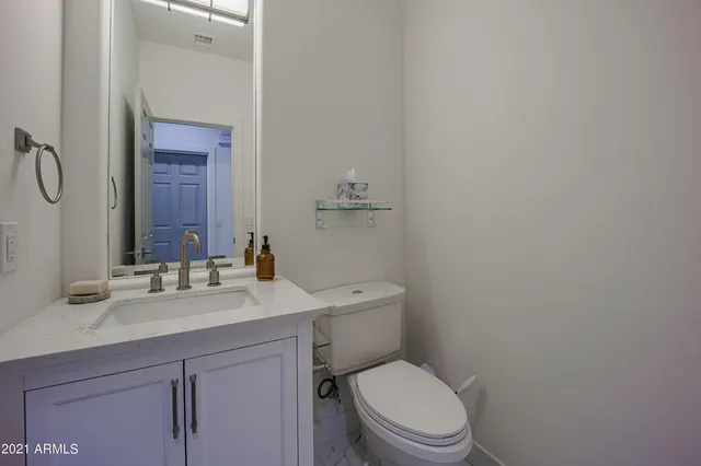a bathroom with a granite countertop toilet sink and mirror