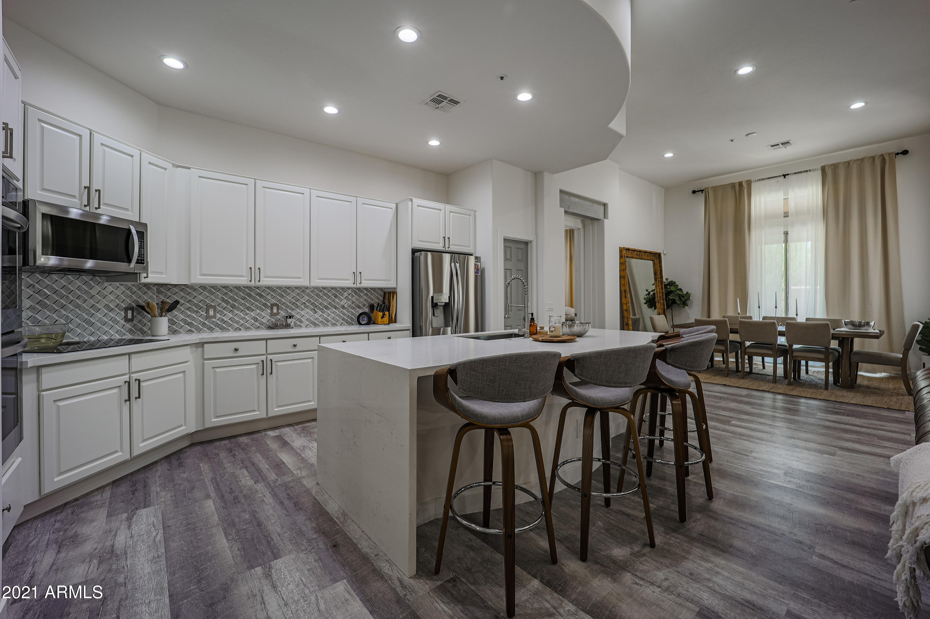 8136 East Beardsley Road Scottsdale, AZ 85255 - Photo 5 of 38 a kitchen with stainless steel appliances granite countertop a stove a sink a microwave a island with a dining table and chairs