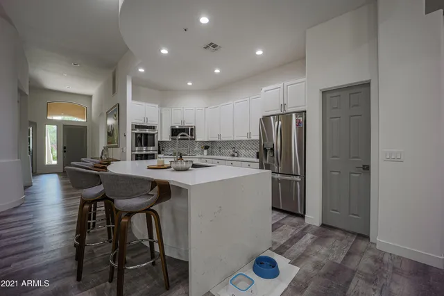 a kitchen with refrigerator and chairs