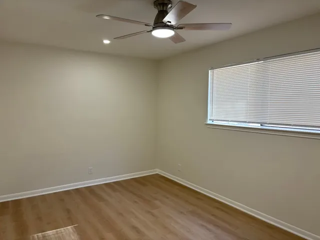 an empty room with a window and a fan