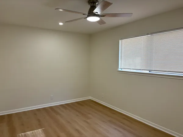 an empty room with a window and a fan