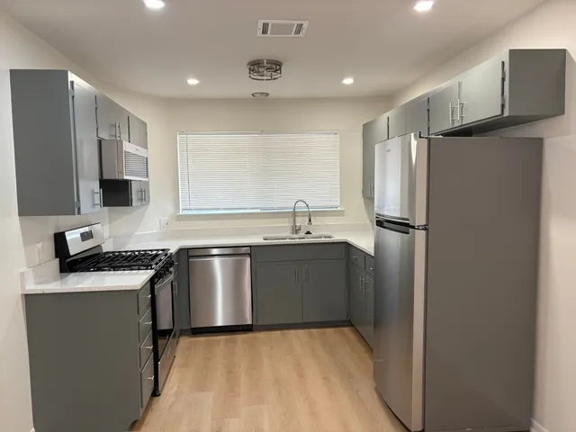 a kitchen with stainless steel appliances granite countertop a stove and a microwave