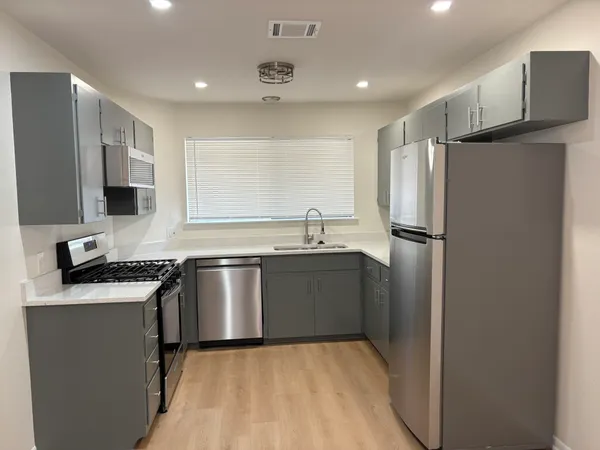 a kitchen with stainless steel appliances granite countertop a stove and a microwave