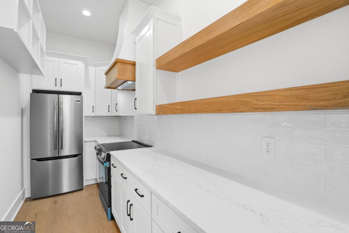 1557 Whitley Road Dacula, GA 30019 - Photo 14 of 46 a kitchen with white cabinets and stainless steel appliances