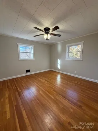 a view of a room with wooden floor and a ceiling fan