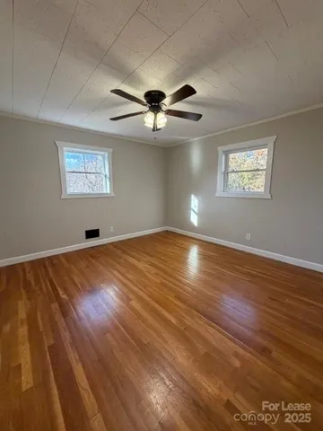 a view of a room with wooden floor and a ceiling fan