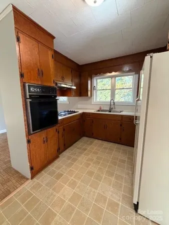 a kitchen with stainless steel appliances a sink and a refrigerator