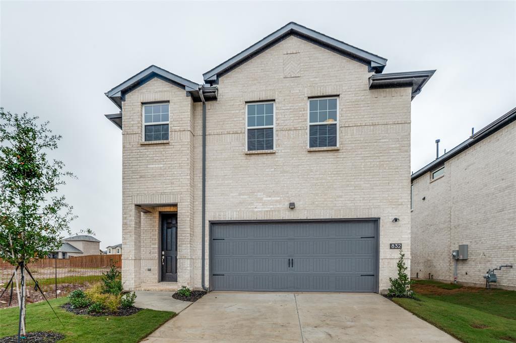 Traditional-style house featuring brick siding, concrete driveway, and an attached garage