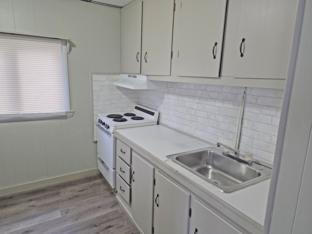 150 Forest Street Fall River, MA 02721 - Photo 6 of 9 a kitchen with sink cabinets and stove