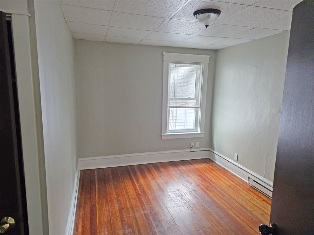 150 Forest Street Fall River, MA 02721 - Photo 7 of 9 an empty room with wooden floor and windows
