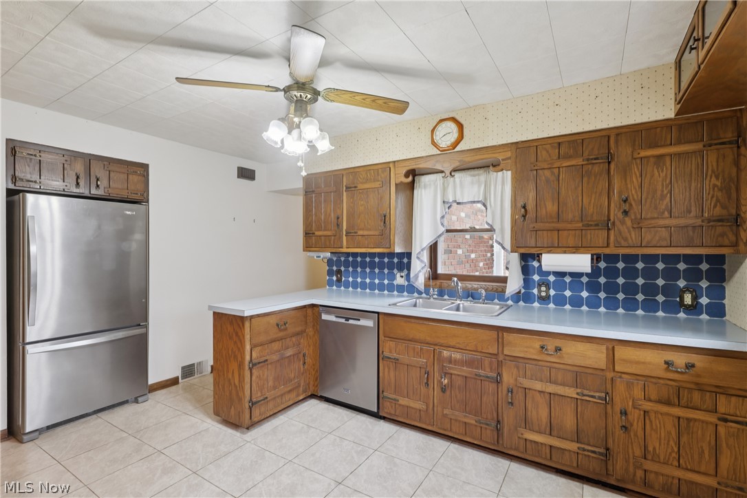 402 Yager Road Clinton, OH 44216 - Photo 13 of 38 Kitchen with sink, decorative backsplash, dishwasher, refrigerator, cabinets, ceiling fan / light and tile flooring