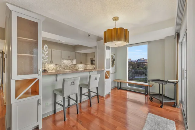 a kitchen with white cabinets and dining table chair