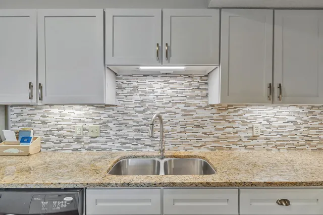 a kitchen with granite countertop a sink and cabinets