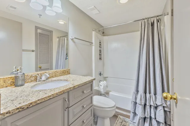 a bathroom with a granite countertop sink toilet and shower