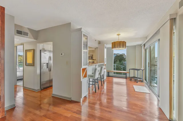 a view of a hallway with wooden floor and windows