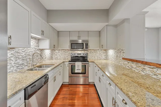 a large kitchen with stainless steel appliances granite countertop a sink stove and oven