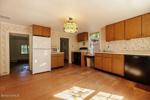 a kitchen with stainless steel appliances granite countertop a stove a sink dishwasher and a refrigerator