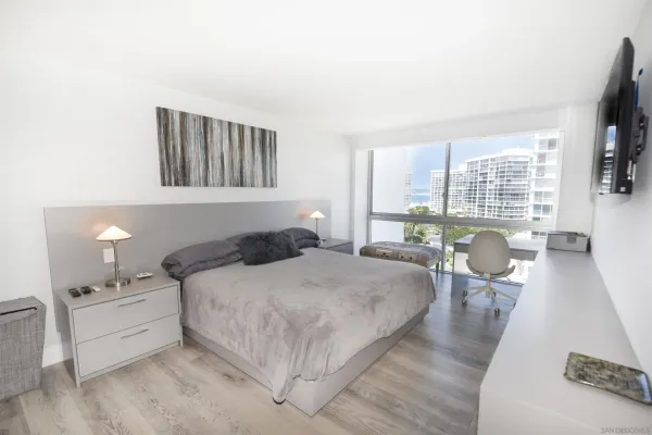 a bedroom with a bed and a large window