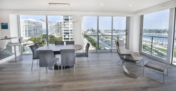a dining room with furniture water view and a floor to ceiling window