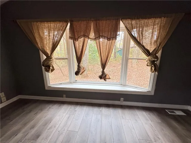 a view of empty room with wooden floor and fireplace